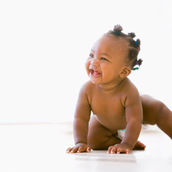 Baby crawling indoors smiling