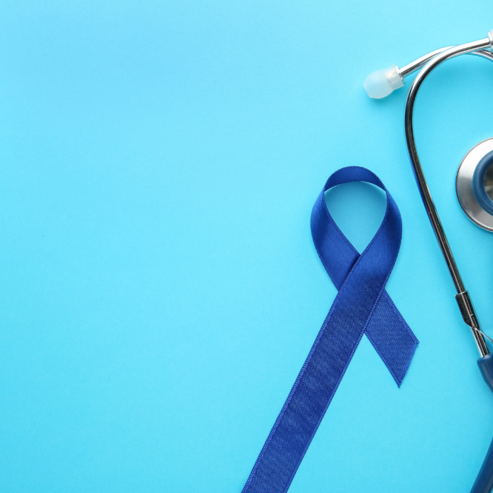 Stethoscope and blue ribbon on teal background